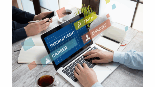 Two coworkers collaborating while searching for candidates on a laptop